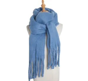 Blue loop yarn winter scarf detail showing soft texture and fringe design close up.