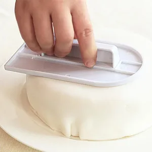 Alisador de tartas de plástico blanco para alisar fondant y tartas de crema fácilmente.