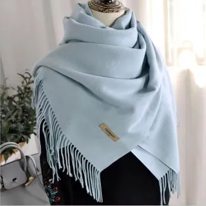 Detailed view of solid color winter scarf with elegant fringes and soft fabric texture.