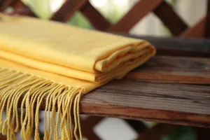 Vista detallada de una bufanda de oración de lino y algodón amarillo brillante con flecos.