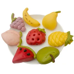 Detailed view of colorful fruit shaped cartoon steamed bun molds and pastry decoration tools.