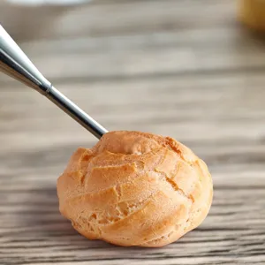 Stainless steel pastry piping nozzle for cream puffs and cakes, detail view showing filling.