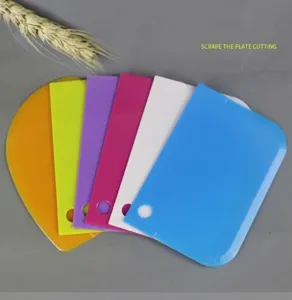 Dettaglio raschietto per torta in plastica, tagliapasta multicolore per cucina e decorazione.