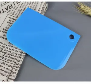 Dettaglio del raschietto per torta in plastica blu, tagliapasta resistente e lisciante.