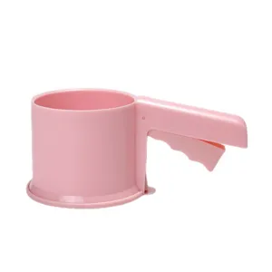 Pink handheld flour sifter detail view, manual baking tool handle and cup structure close up.