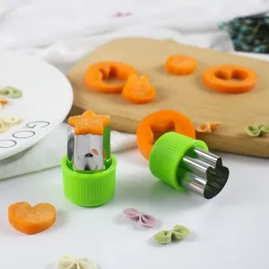 Stainless steel vegetable fruit cutter mold detail showing green handle and star carrot shapes.