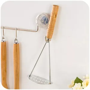 Stainless steel potato masher detail view showcasing durable wooden handle and mash plate.