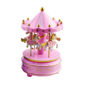 Close-up detail of the pink and white carousel music box with golden stars and cute miniature horses.