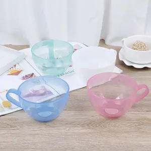Detailed shot of colorful transparent plastic mixing bowls set on a wooden table, ideal for baking.