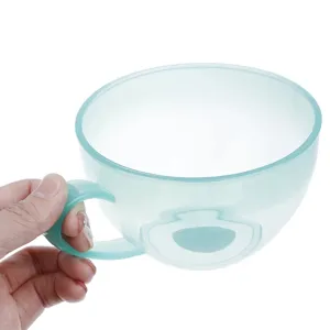 Detail shot of light green plastic mixing bowl handle, baking tool close up view view.