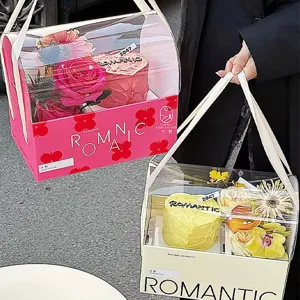 Detalle de caja de regalo transparente con arreglo floral y pastel dentro para lindos obsequios.