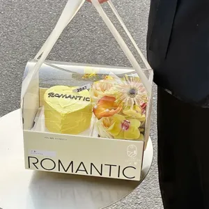 Vista detallada de la caja de regalo transparente con pastel amarillo y flores frescas.