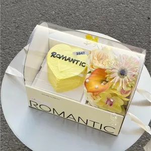 Vista detallada de tarta corazón amarillo y caja regalo flores con embalaje transparente portátil.