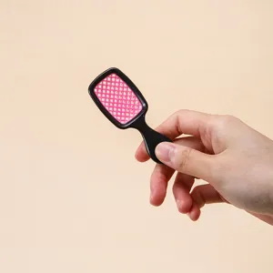 Vista dettagliata della mini spazzola per capelli, dimensioni compatte e design pratico.