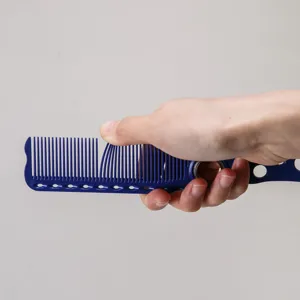 Professioneller Friseurhaarschnittkamm Detail mit 360 Grad Rotationslager und Punkten.