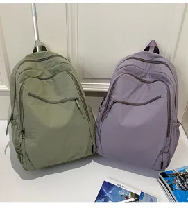 Vista di dettaglio dello zaino da viaggio in nylon verde e viola, grande, casual e pratico.