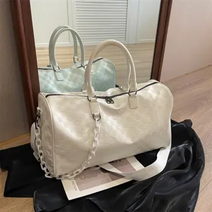 Große weiße Reisetasche mit Karomuster, Schulterriemen und stylischer Kette für Damen.