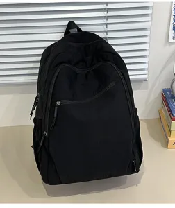 Vista dettagliata dello zaino nero minimalista che mostra tessuto resistente e comode zip.