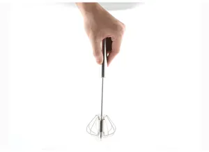 Detail view of the stainless steel push whisk showing its mechanism and fine metal wires.