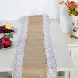 Detail view of rustic burlap table runner with white lace trim for wedding decor and dining tables.