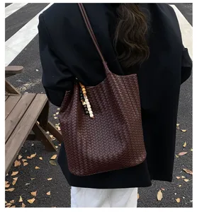 Woven shoulder tote bag for women, dark brown leather commuter bag with chic beaded charm decor.