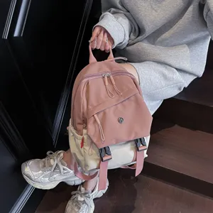 Mochila casual minimalista de nylon rosa y beige con múltiples bolsillos vista frontal