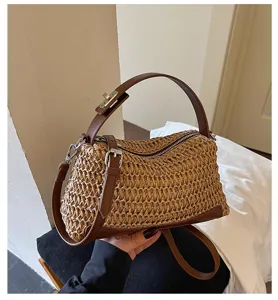 Woven straw shoulder bag detail showing premium texture, brown leather handle, and metal zipper.