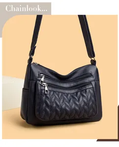 Detail of women soft leather crossbody shoulder bag with woven pocket and metal zippers.