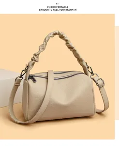 Detailed view of retro leather pillow crossbody bag, ruched handle, elegant beige handbag style.