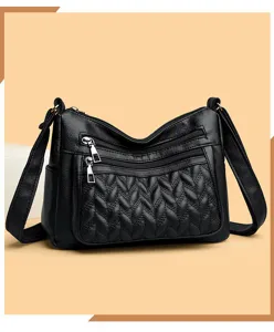 Detailed view of black soft leather crossbody bag with multiple zip pockets and texture.