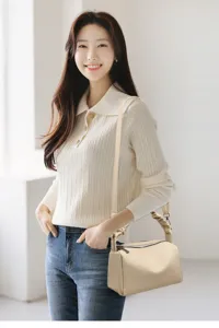Detailed view of stylish beige pillow shoulder bag with trendy gathered handle and strap.