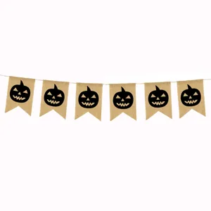 Close-up detail of Halloween burlap banner flags featuring black carved pumpkin silhouettes.