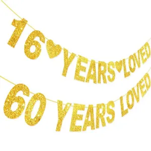 Close-up detail shot of gold glitter number 16 and 60 years loved party banner decoration.