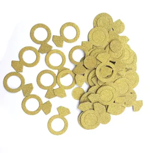 Primer plano de confeti dorado brillante con forma de anillo de compromiso para detalles de fiesta.