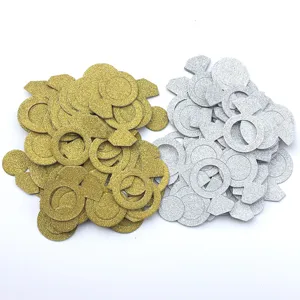 Détails de confettis en anneau de diamant pailleté, déco de table dorée et argentée.