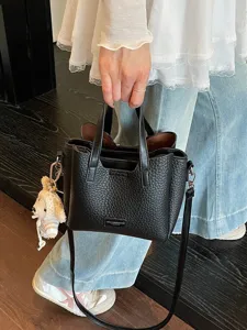 Stylish black leather tote bag for women, versatile crossbody purse with cute dog pendant.