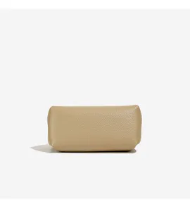 Detail view of a minimalist women's leather cosmetic bag in chic beige litchi grain texture.