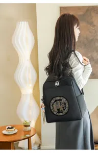 Stylish women's black backpack with elephant rhinestone pattern for casual travel commute.