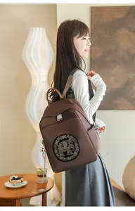 Detailed view of the stylish brown women backpack featuring an elegant rhinestone elephant patch.