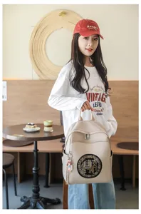 Fashionable women's beige PU leather backpack with cute elephant embroidery design for casual commute.