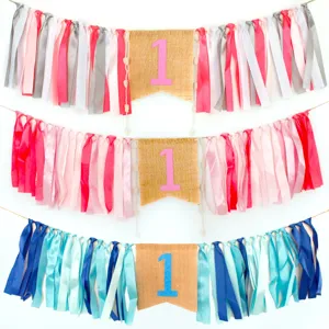 Baby 1st birthday party banner detail, colorful ribbon and burlap tassel high chair decor.