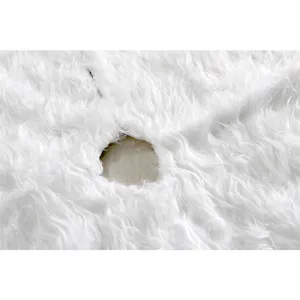 Detail de la belle jupe de sapin de Noel en peluche blanche douce avec un trou rond.