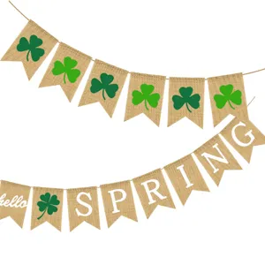 Burlap banner garland featuring green shamrock prints and white hello spring text details.