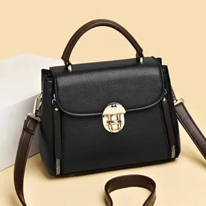 Classic black leather shoulder bag with chic gold lock closure, retro top handle design.