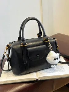 Fashionable black commuter handbag with white fluffy pendant, casual shoulder crossbody bag.