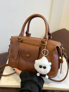 Stylish brown PU leather top handle shoulder crossbody bag with cute plush keychain.