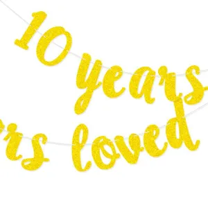 Gold glitter 10 years loved banner detail close-up for happy anniversary party decor