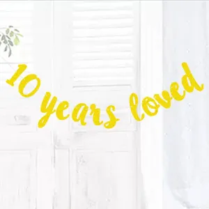 Detail shot of the glittering gold 10 years loved banner hanging for party decoration close up.