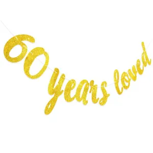 Close-up detail of gold glitter 60 years loved banner for birthday party decoration.