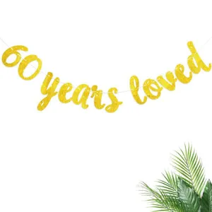 Close-up detail of the gold glitter 60 years loved letter banner for birthday party decor.